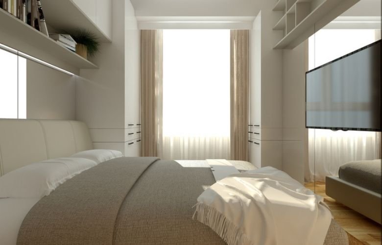quarto de casal pequeno com jogo de cama de cor clara e tv em par de com objetos decorativos