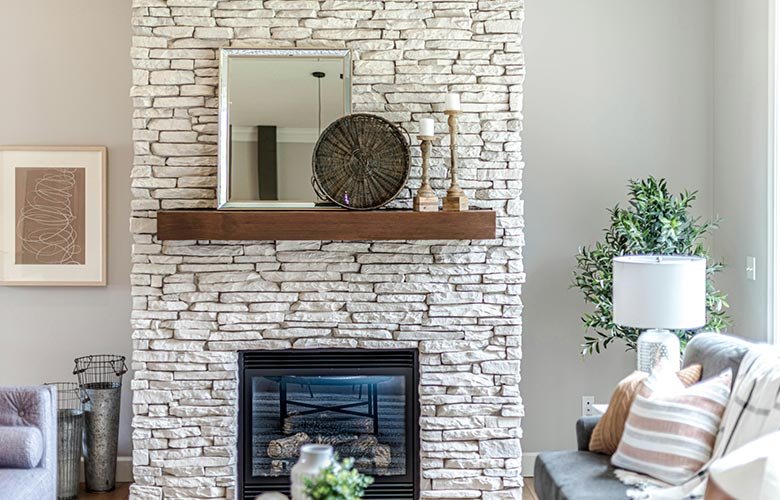 Lareira moderna revestida com pedra madeira em uma sala de estar sofisticada, com decoração minimalista e elementos naturais.